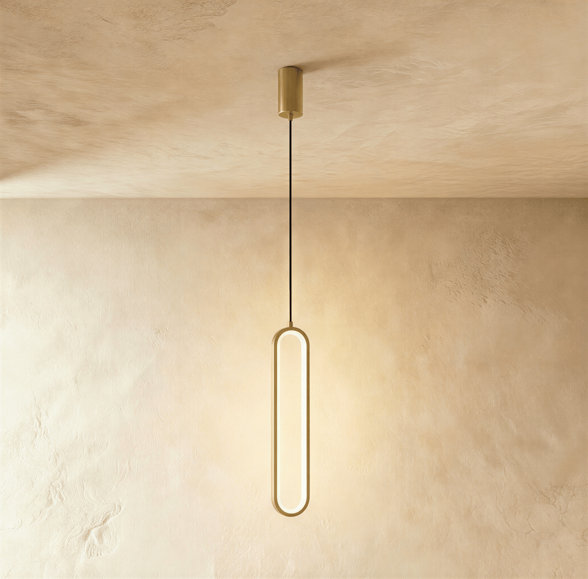 Clérachic compact gold stadium-shaped LED loop pendant on a short cord and round gold canopy, on a limewash wall.