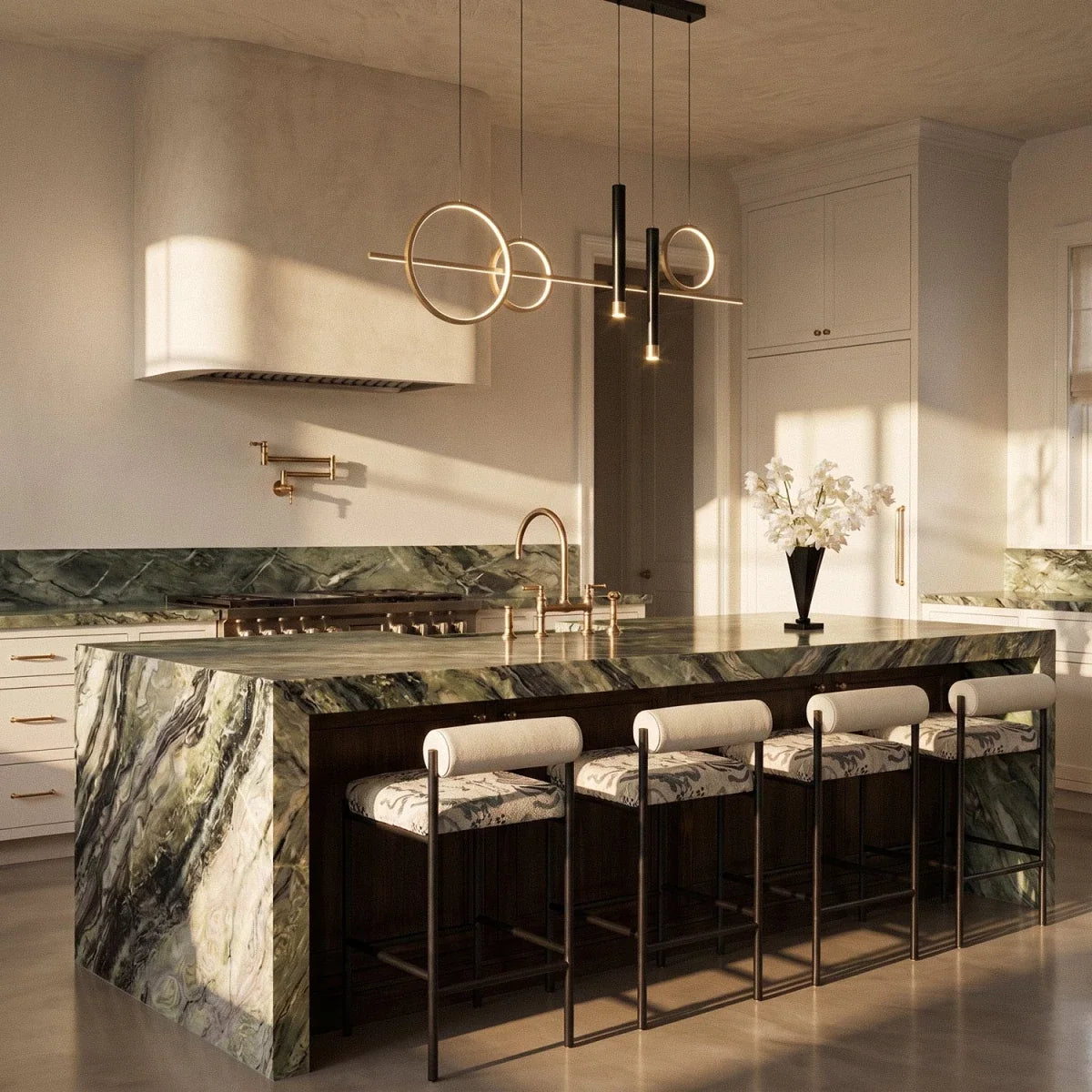 Clérachic gold ring and bar pendant light with two black spot cylinders hung over a green marble kitchen island.
