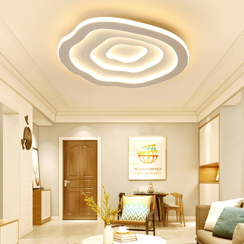Clérachic Ripple Spiral flush mount lighting a warm hallway with a wooden door and dining nook beyond.