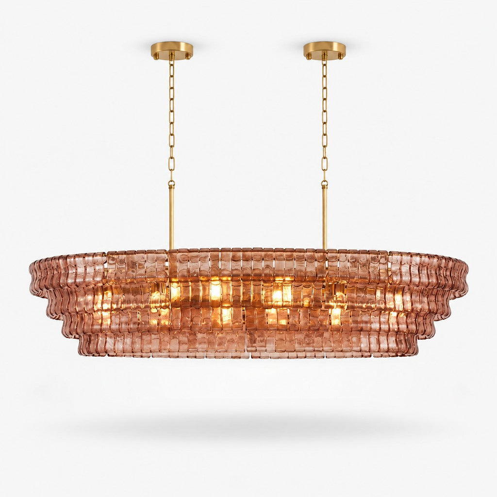 Rose-pink glass tiers on this Clérachic linear chandelier, hung from two gold canopies on a plain white backdrop.