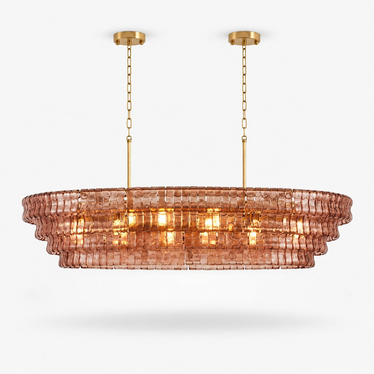 Rose-pink glass tiers on this Clérachic linear chandelier, hung from two gold canopies on a plain white backdrop.