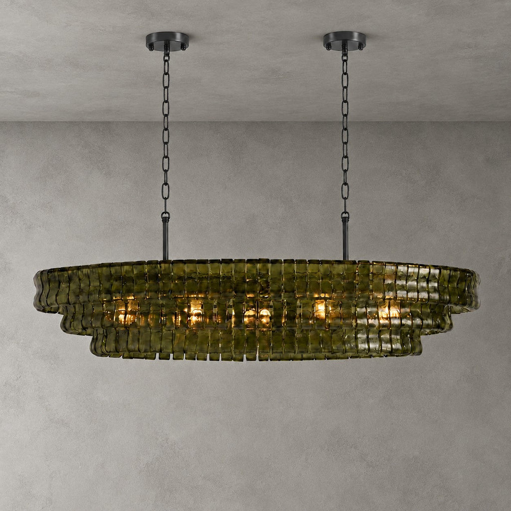Green glass on this Clérachic chandelier, hung from two black round canopies and black chains against a grey backdrop.