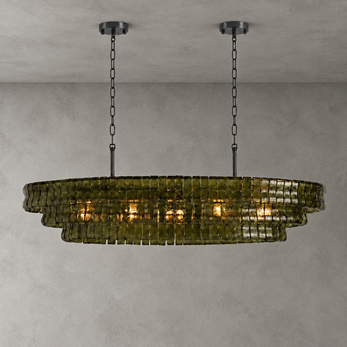 Green glass on this Clérachic chandelier, hung from two black round canopies and black chains against a grey backdrop.