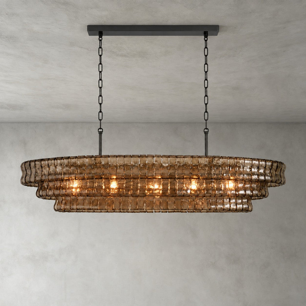 This Clérachic chandelier in smoke-brown glass hangs from a black long canopy on a black chain, lit on a grey backdrop.