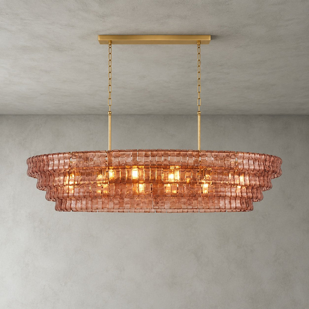 A four-tier rose-pink Clérachic chandelier hung from a gold long canopy bar, its bulbs glowing through the glass.