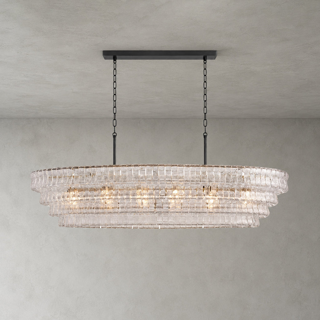 Four tiers of clear rippled glass on a Clérachic chandelier, hung from a black long canopy bar on a grey backdrop.
