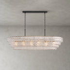 Four tiers of clear rippled glass on a Clérachic chandelier, hung from a black long canopy bar on a grey backdrop.