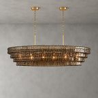 A smoke-brown Clérachic chandelier with four glass tiers, hung from two gold round canopies against a grey backdrop.