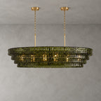 Four green-glass tiers on this Clérachic chandelier with two gold round canopies, glowing warmly on a grey wall.