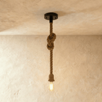 Clérachic hemp rope pendant with a longer drop, a black ceiling plate, a knot near the top and a bare filament bulb below.