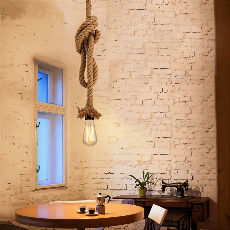Clérachic single hemp rope pendant with a large knot and a filament bulb, hung in a whitewashed brick room beside a round table.