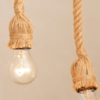 Close view of two Clérachic hemp rope pendants showing the frayed rope socket covers, twine binding and round clear bulbs.