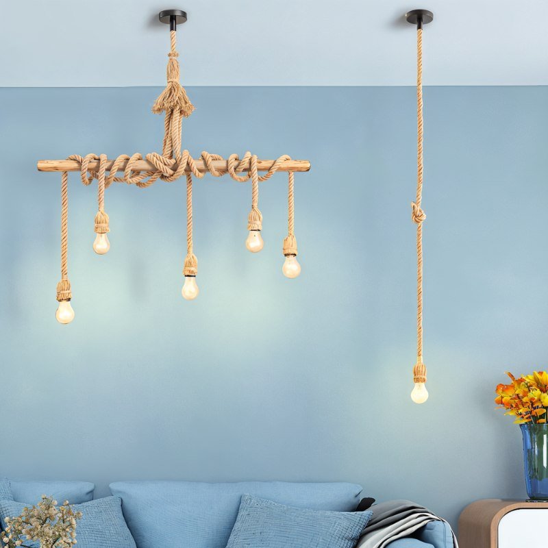 Clérachic five-bulb timber and rope pendant beside a single rope drop, both against a pale blue wall above a sofa.