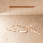 Clérachic chandelier's rose gold rings interlock loosely, hanging from a slim bar on three thin cables.