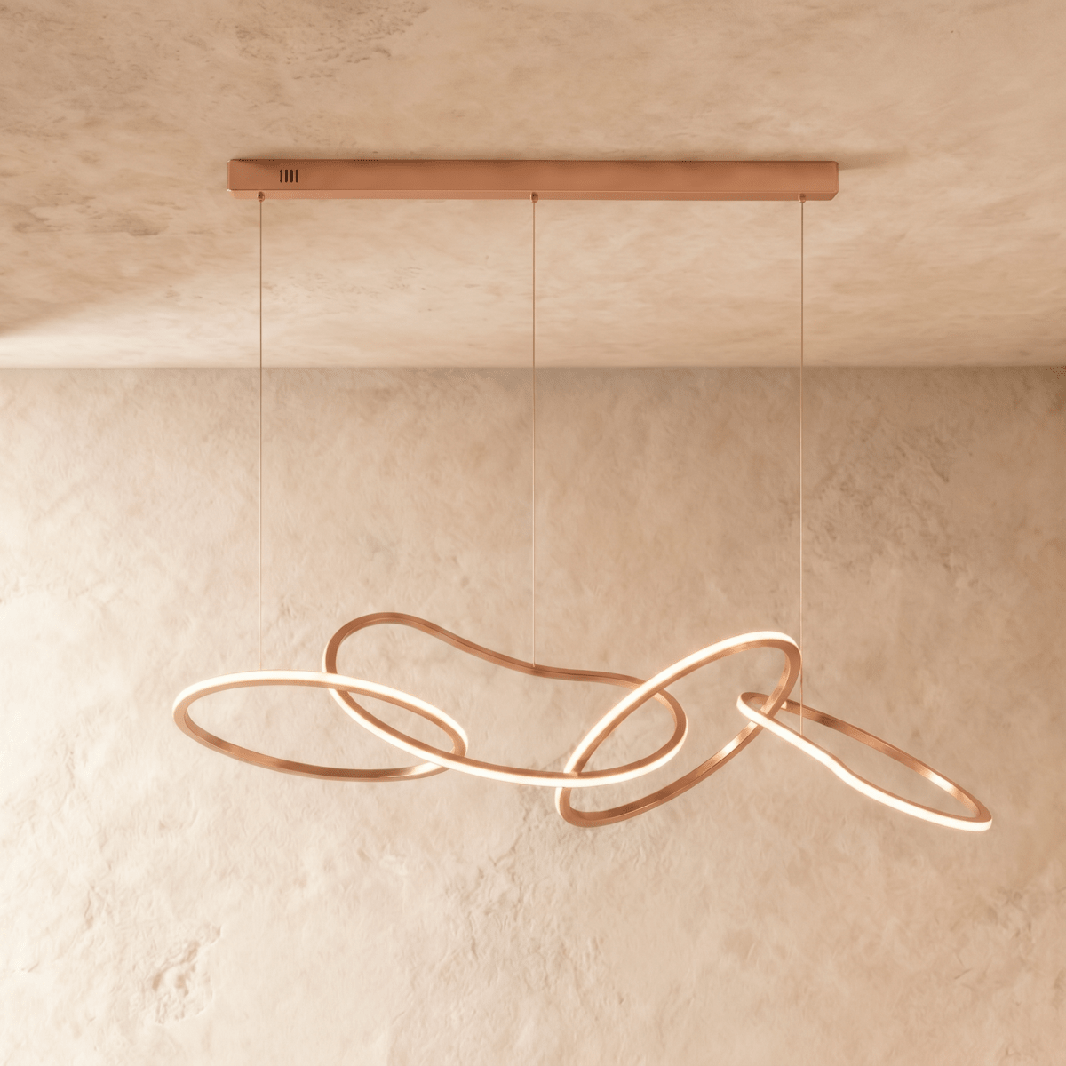 Clérachic chandelier's rose gold rings interlock loosely, hanging from a slim bar on three thin cables.
