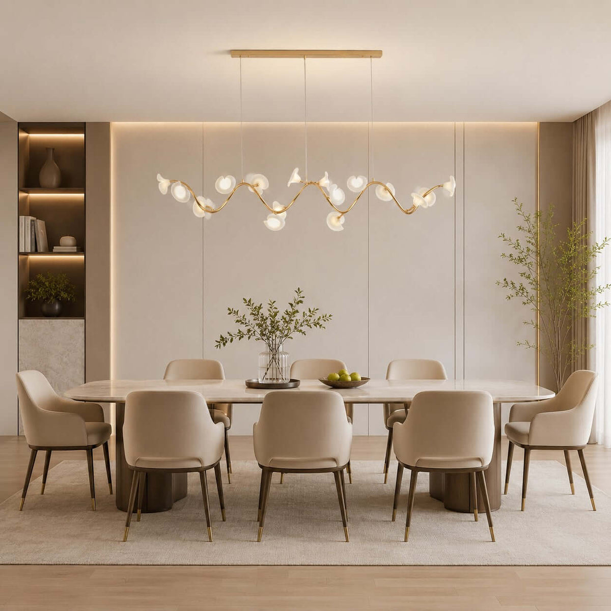 Linear Clérachic chandelier with ceramic petals on a wavy gold branch, hung above a long dining table with taupe chairs.