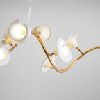 Close view of curled white ceramic petals, each with a bulb inside, on the twisting gold arm of this Clérachic chandelier.