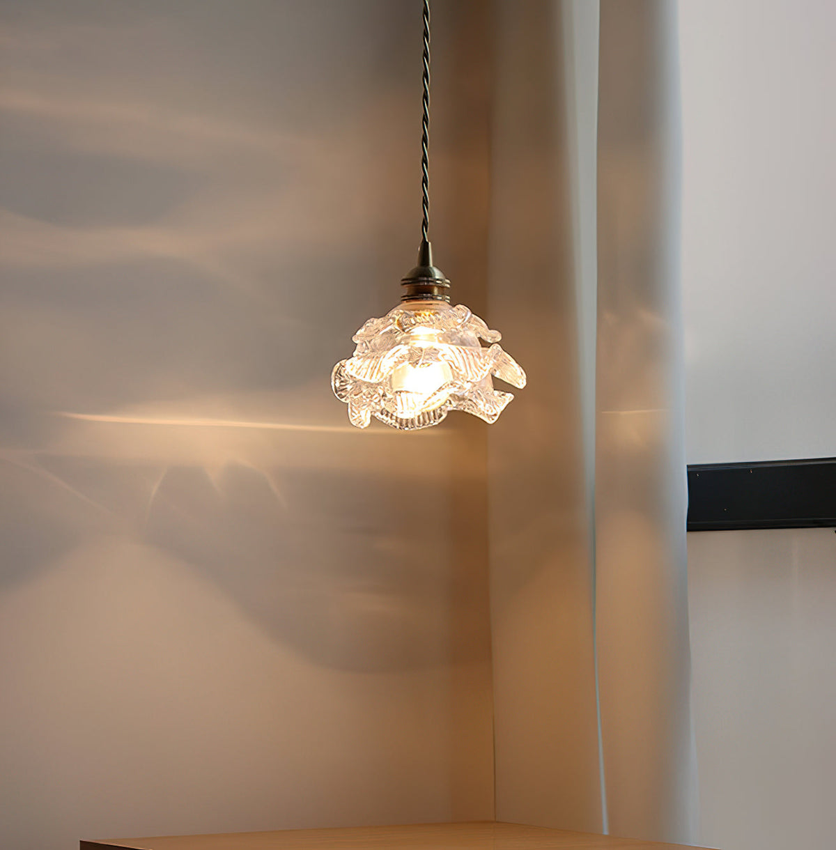 Soft light from the glass shade of this Clérachic wall light throws ripples of gold across a curtain and wall.