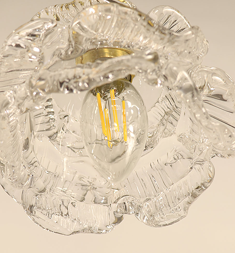 Looking up into the glass shade of this Clérachic wall light, a filament bulb sits among the ribbed, ruffled petals.