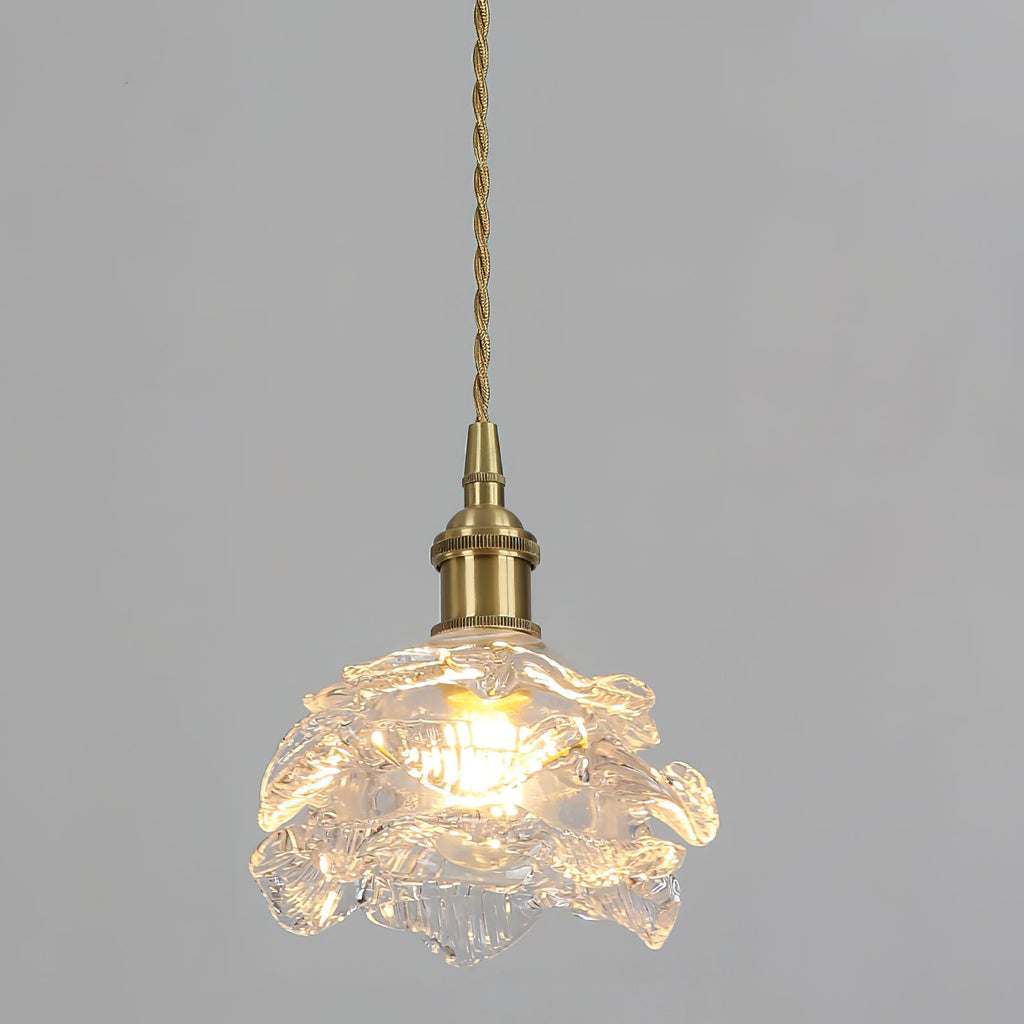 Warm light spreads through the ribbed glass shade of this Clérachic wall light on its twisted cord, against a pale grey wall.