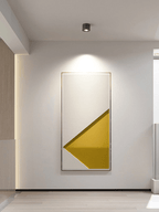 A single dark Clérachic spotlight on a hallway ceiling, washing a large framed abstract print with a pool of warm light.