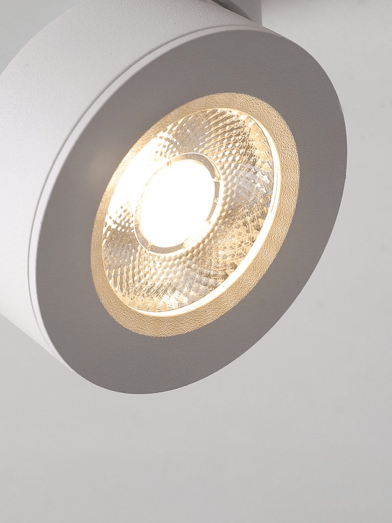 Close view of the white Clérachic spotlight head, with its warm LED inside a ribbed, honeycomb-textured reflector.