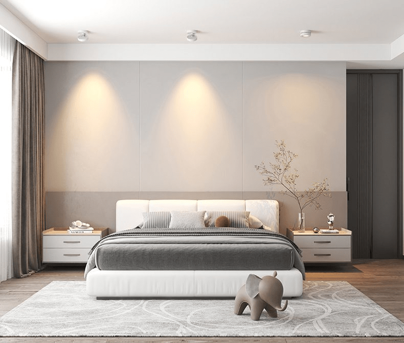 White Clérachic spotlights along a bedroom ceiling, throwing three soft pools of light on the wall behind a white bed.