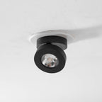 Underside view of a black Clérachic spotlight in a white ring, with a ribbed reflector and LED facing down.