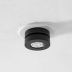 Black Clérachic spotlight with its head turned flat against the base, its reflector facing straight down from a white ceiling ring.