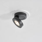 Black Clérachic spotlight with its lit head turned to the side, seen from below in a white ceiling ring.