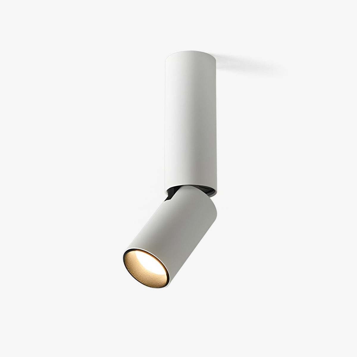 This Clérachic ceiling spotlight in white on a plain backdrop, a slim cylinder with an angled head and a warm light glowing from its lens.