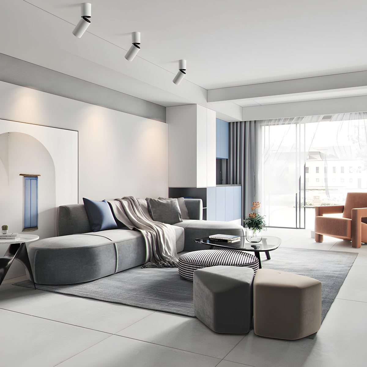 Three white Clérachic spotlights with angled heads sit high on the ceiling of a bright, open living room.