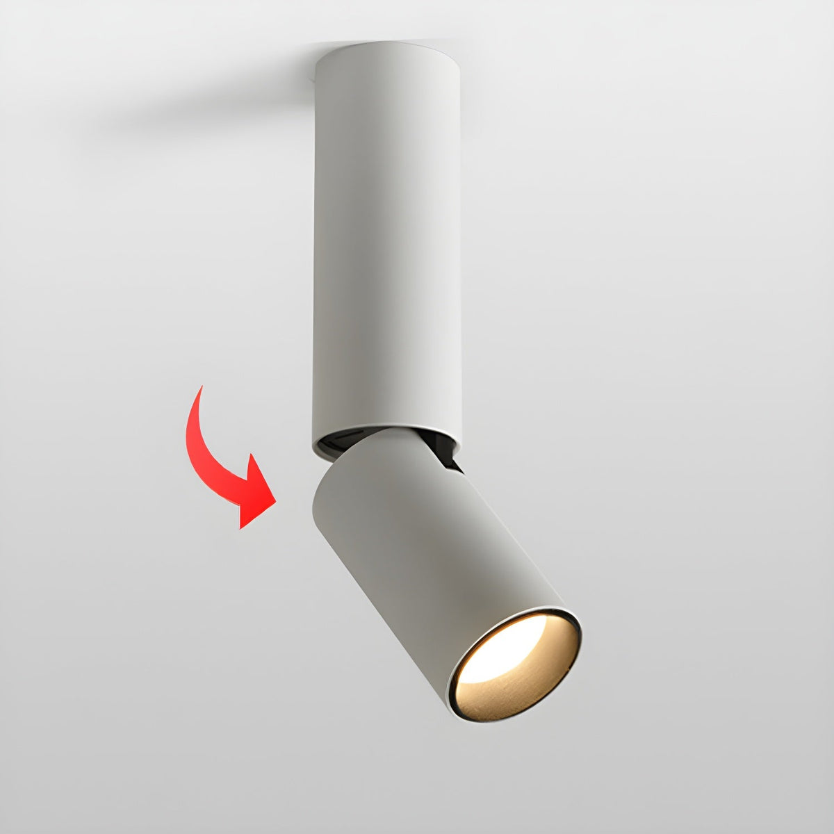 White Clérachic spotlight with a red arrow showing how the lower head swivels away from the pole, lit warm.