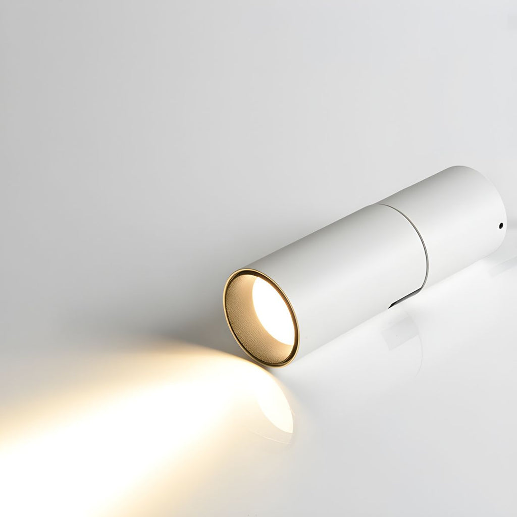 Close view of a white Clérachic spotlight head lying on its side, throwing a narrow beam of warm light across the surface.