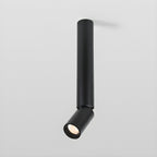 A black Clérachic ceiling spotlight with a long pole and an angled head, seen from slightly below on a light grey backdrop.