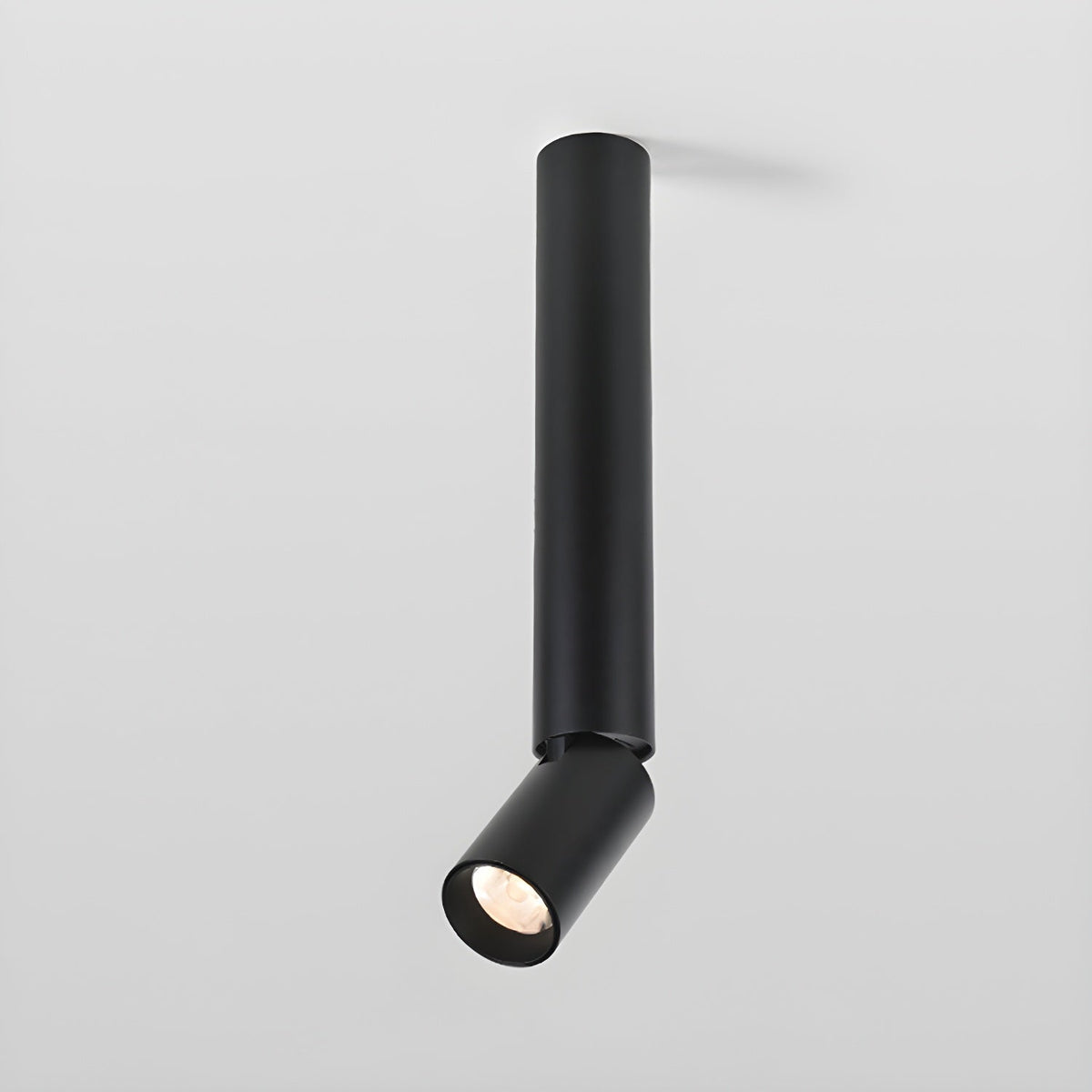 A black Clérachic ceiling spotlight with a long pole and an angled head, seen from slightly below on a light grey backdrop.