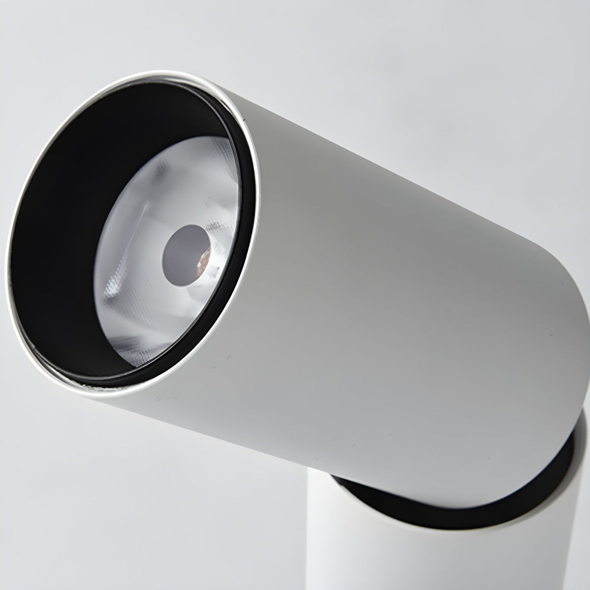 Close view of the lens of a white Clérachic spotlight, a black inner ring around a small bright LED.