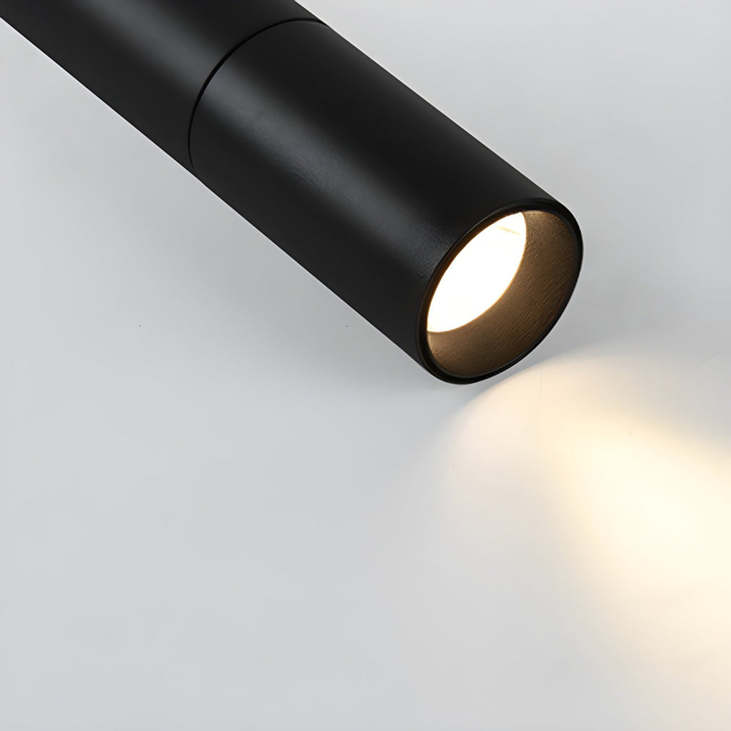 Close view of a black Clérachic spotlight head with a warm light and a soft pool of light spreading across the surface.