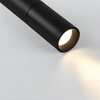 Close view of a black Clérachic spotlight head with a warm light and a soft pool of light spreading across the surface.
