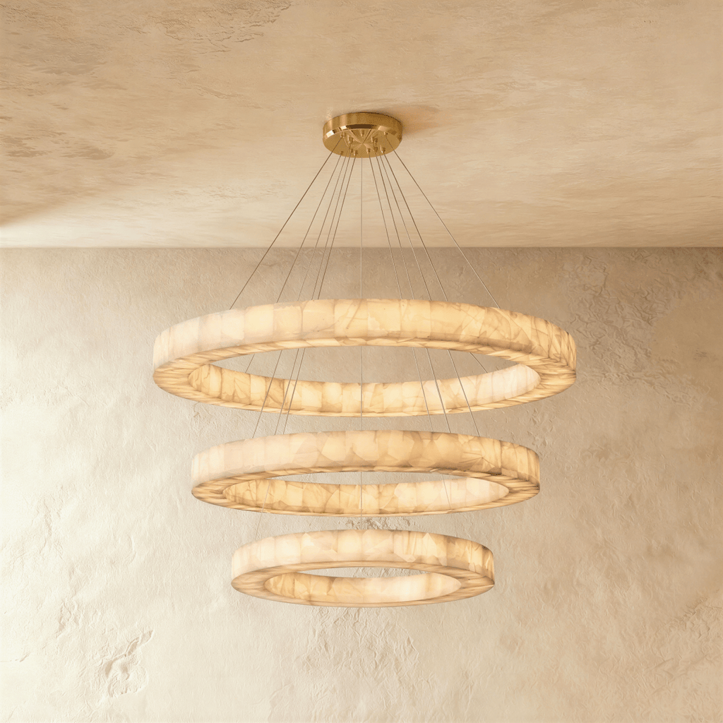 Clérachic three-tier alabaster ring chandelier, its stacked rings glowing warm beneath a round ceiling canopy.