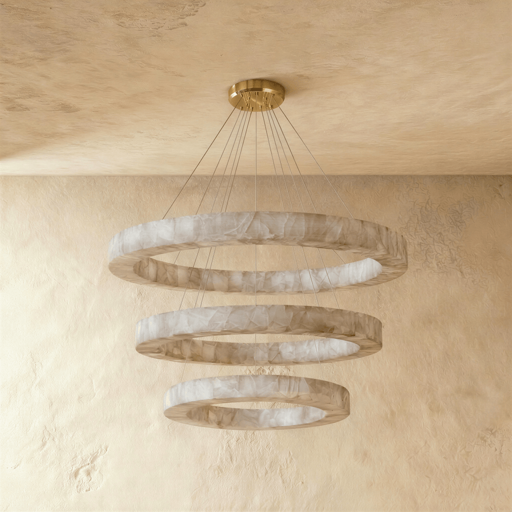 Clérachic alabaster chandelier with three stacked rings, hung on fine cords from a brass ceiling plate.