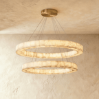 Clérachic two-tier alabaster ring chandelier glowing warm, its stacked rings suspended from a round ceiling plate.
