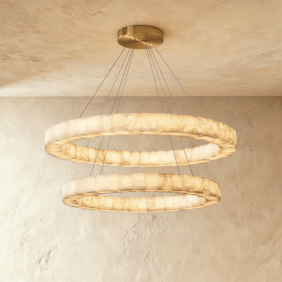 Clérachic two-tier alabaster ring chandelier glowing warm, its stacked rings suspended from a round ceiling plate.