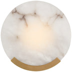 Clérachic Round Alabaster Wall Sconce lit head on, its brass bracket curving under a disc of grey-veined white stone.