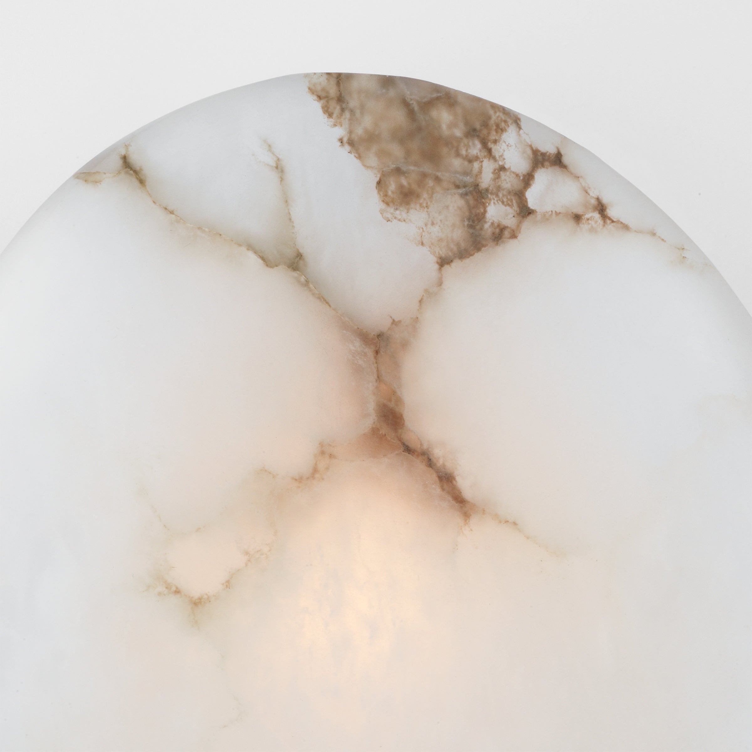 Close-up of the Clérachic alabaster face, brown veining spreading across the stone with the glow rising from below.