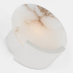 Clérachic alabaster sconce in chrome, tipped to show the mirrored bracket behind the warmly lit veined disc.