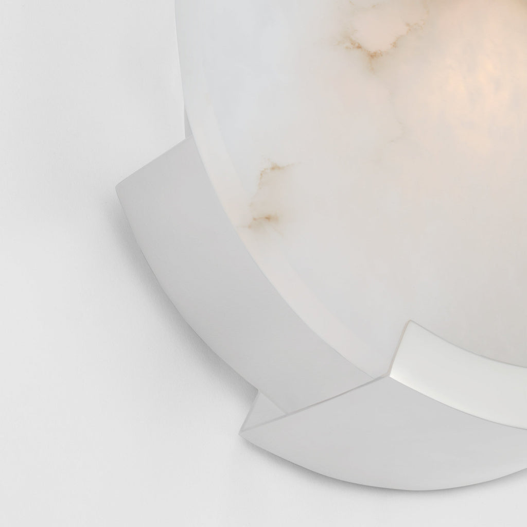 Chrome bracket detail on the Clérachic wall sconce, its bright curve set against the softly lit alabaster face.