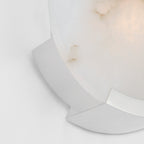 Chrome bracket detail on the Clérachic wall sconce, its bright curve set against the softly lit alabaster face.