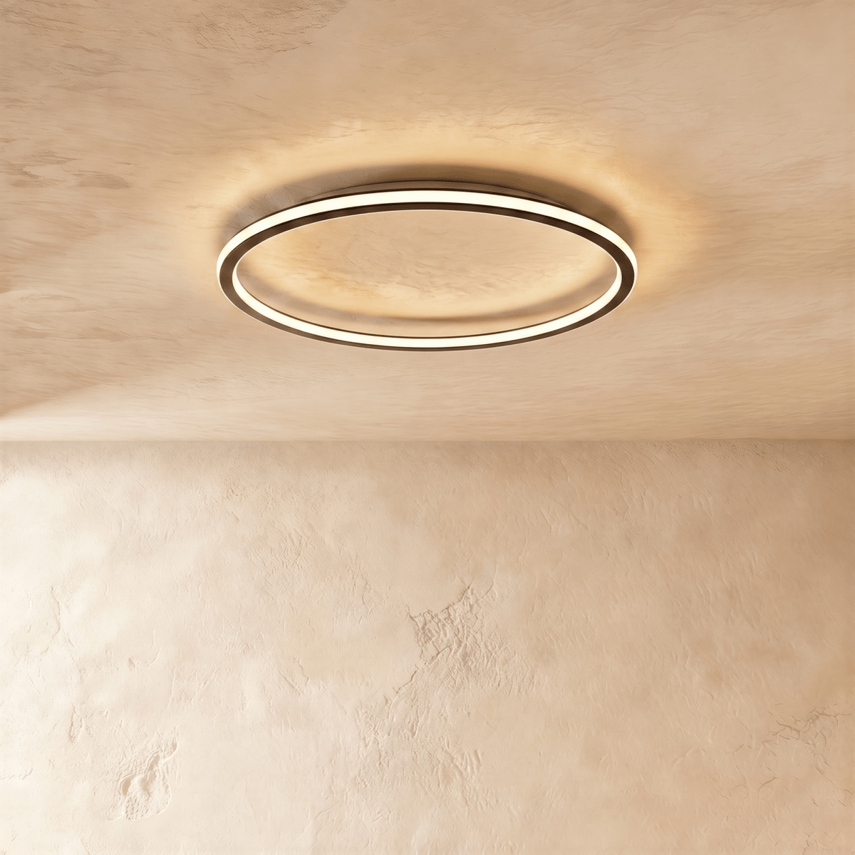 The Clérachic matte black ring light seen from below, its warm LED edge lighting the plaster ceiling above.