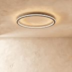 Close angle on the Clérachic matte black ceiling ring, showing the slim frame and warm glow along its rim.